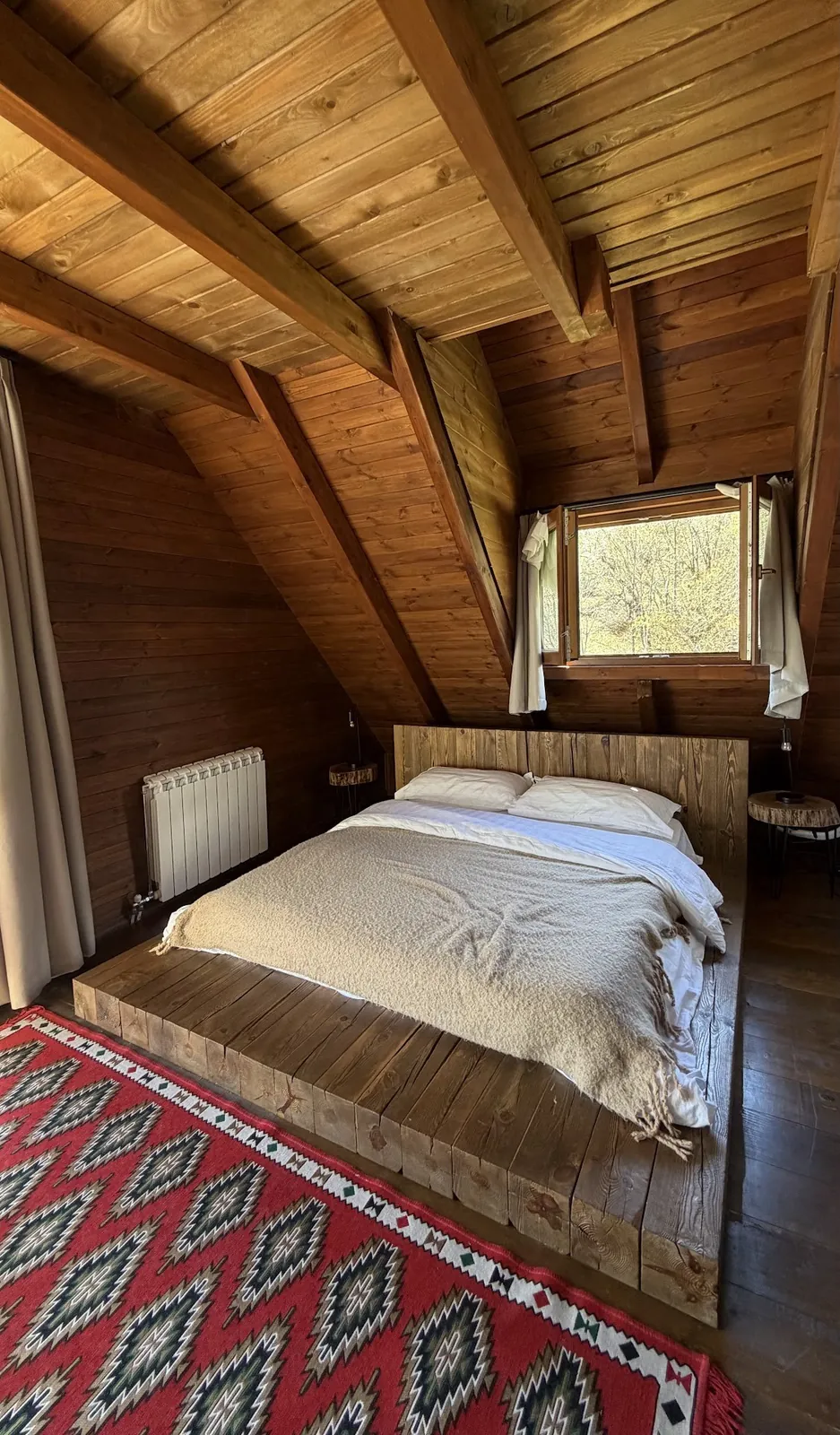 Wood-panelled attic room with a red rug