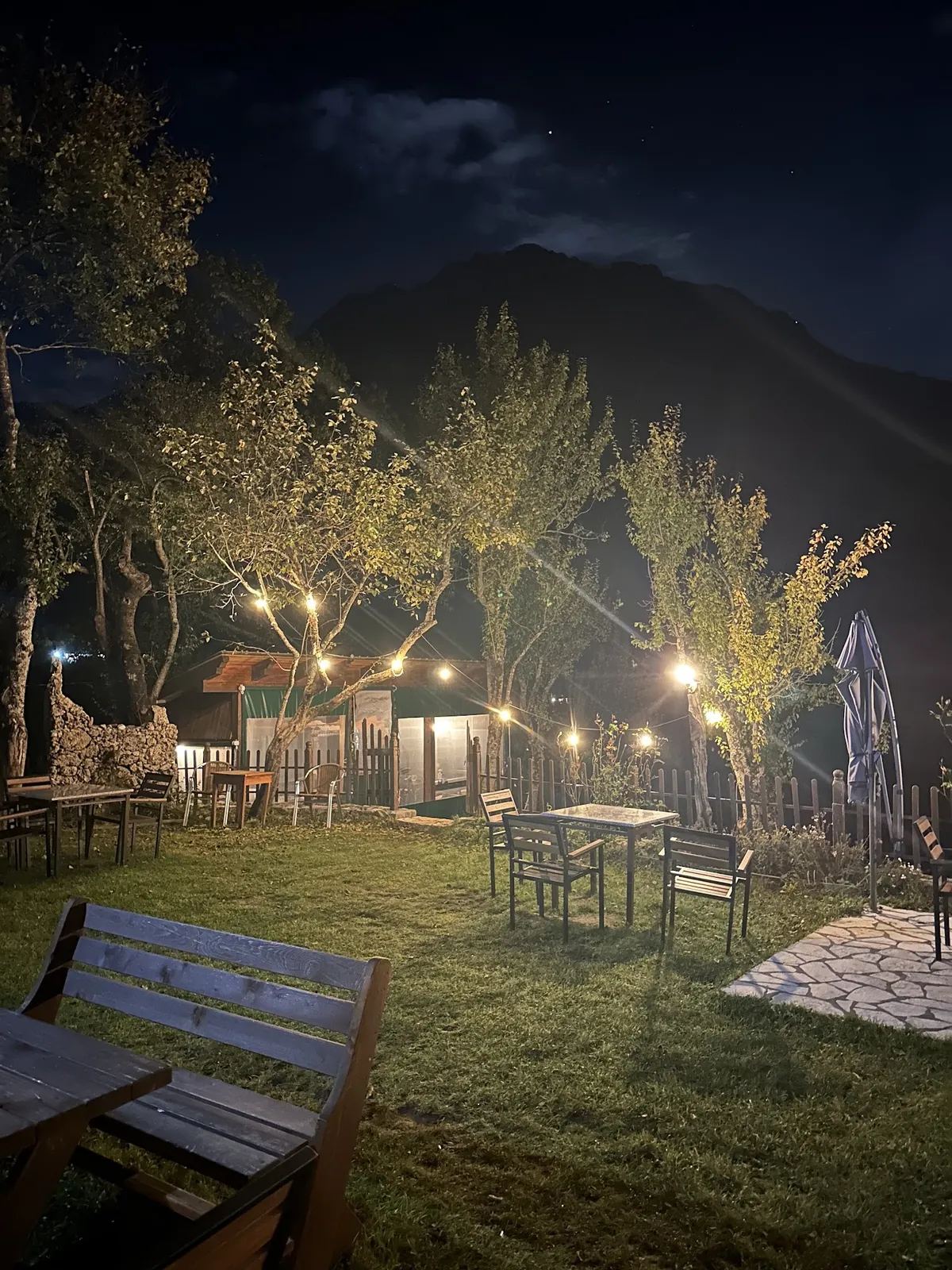 Garden tables under string lights at night